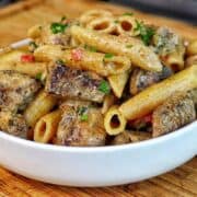 Creamy Rasta Pasta with jerk chicken made with penne pasta, seasoned chicken, colorful peppers, and a rich creamy jerk sauce garnished with fresh parsley.