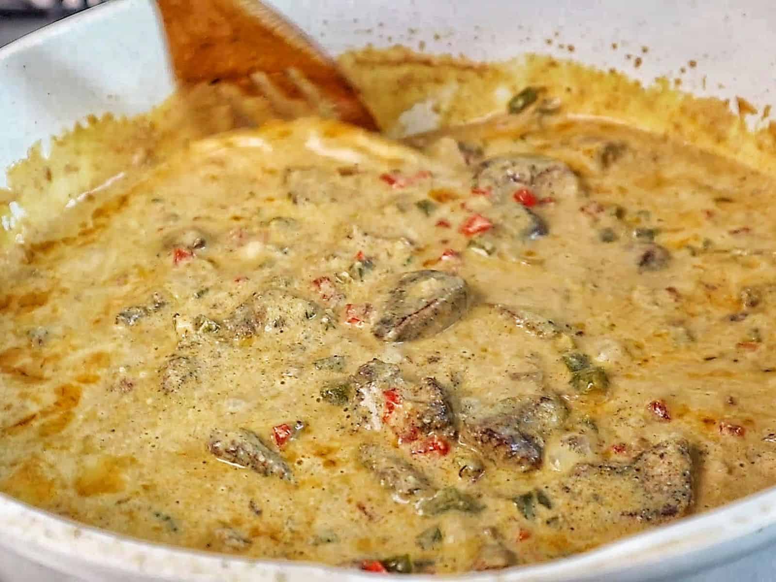 Creamy Rasta Pasta with jerk chicken made with penne pasta, seasoned chicken, colorful peppers, and a rich creamy jerk sauce garnished with fresh parsley.