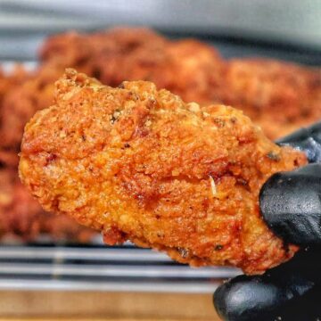 Crispy golden fried chicken wings coated in seasoned flour, with a crunchy textured crust.