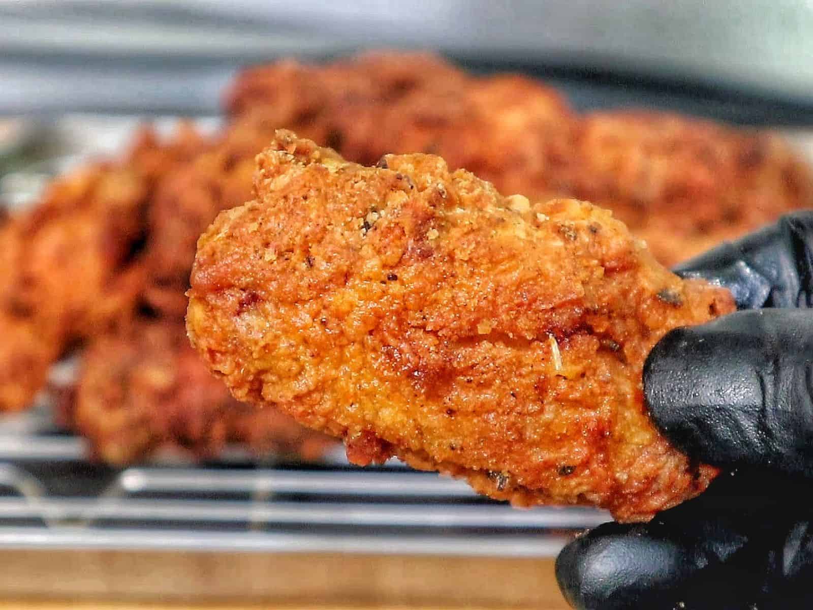 Crispy golden fried chicken wings coated in seasoned flour, with a crunchy textured crust.