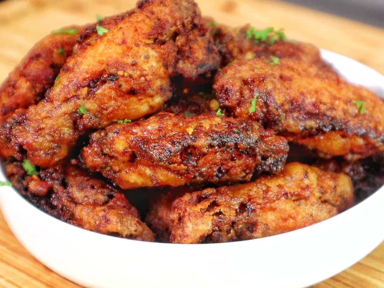 crispy Brazilian-style chicken wings fried until deep golden brown, topped with sautéed garlic, fresh parsley, and a drizzle of garlic-infused olive oil.