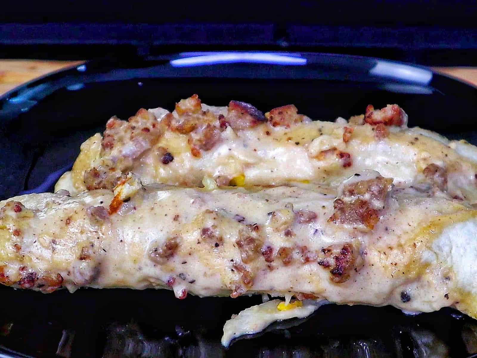 Breakfast enchiladas topped with creamy homemade sausage gravy and melted cheese. The enchiladas are stuffed with scrambled eggs, sausage, hash browns, and cheese.