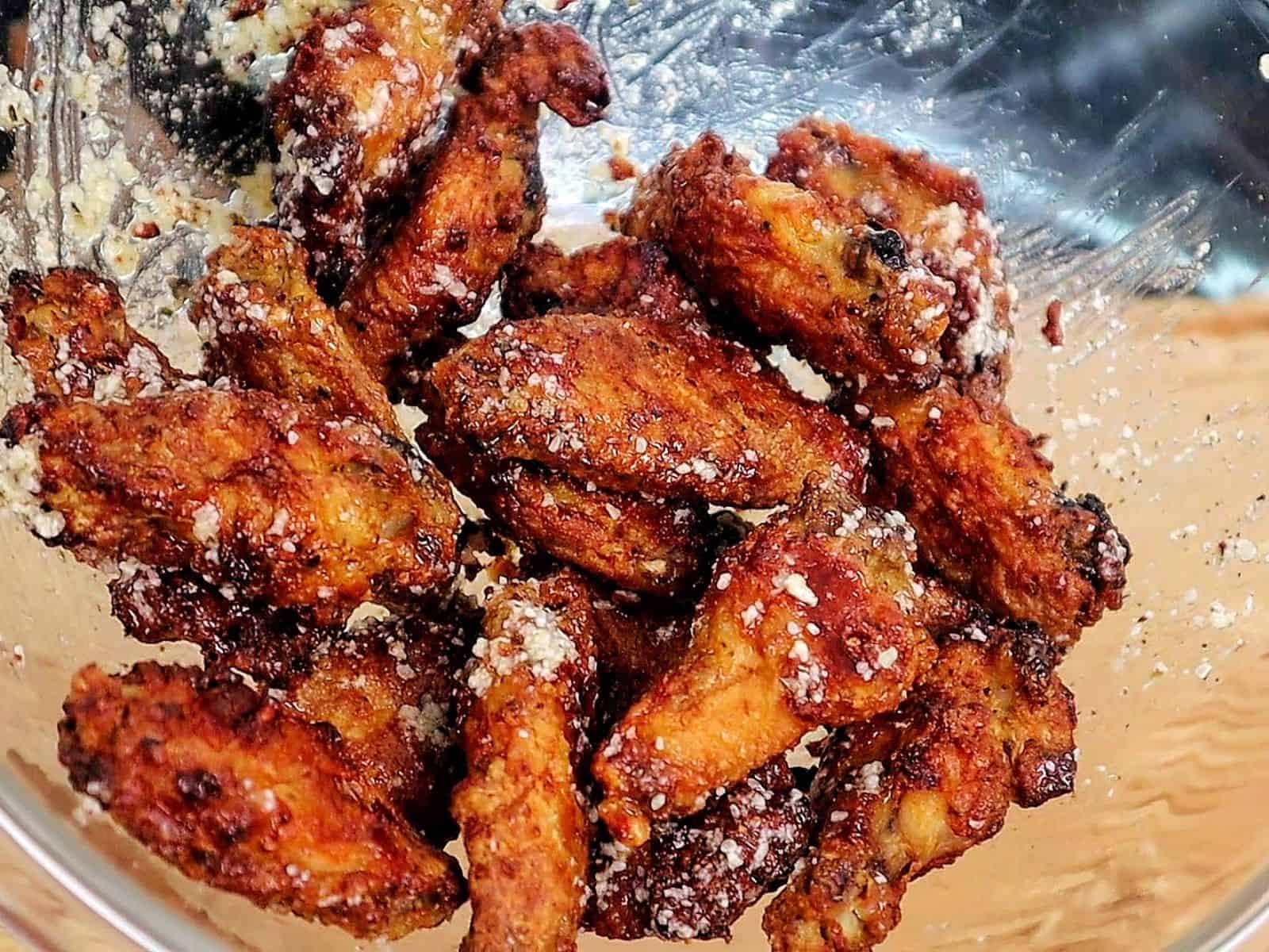 Crispy golden brown garlic Parmesan chicken wings coated in a buttery garlic sauce and topped with grated Parmesan cheese.