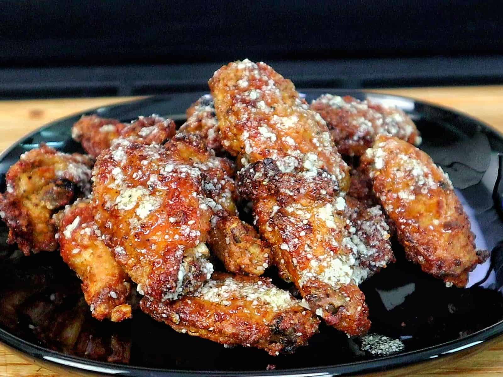 Crispy golden brown garlic Parmesan chicken wings coated in a buttery garlic sauce and topped with grated Parmesan cheese.