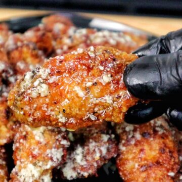 Crispy golden brown garlic Parmesan chicken wings coated in a buttery garlic sauce and topped with grated Parmesan cheese.