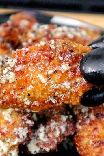 Crispy golden brown garlic Parmesan chicken wings coated in a buttery garlic sauce and topped with grated Parmesan cheese.