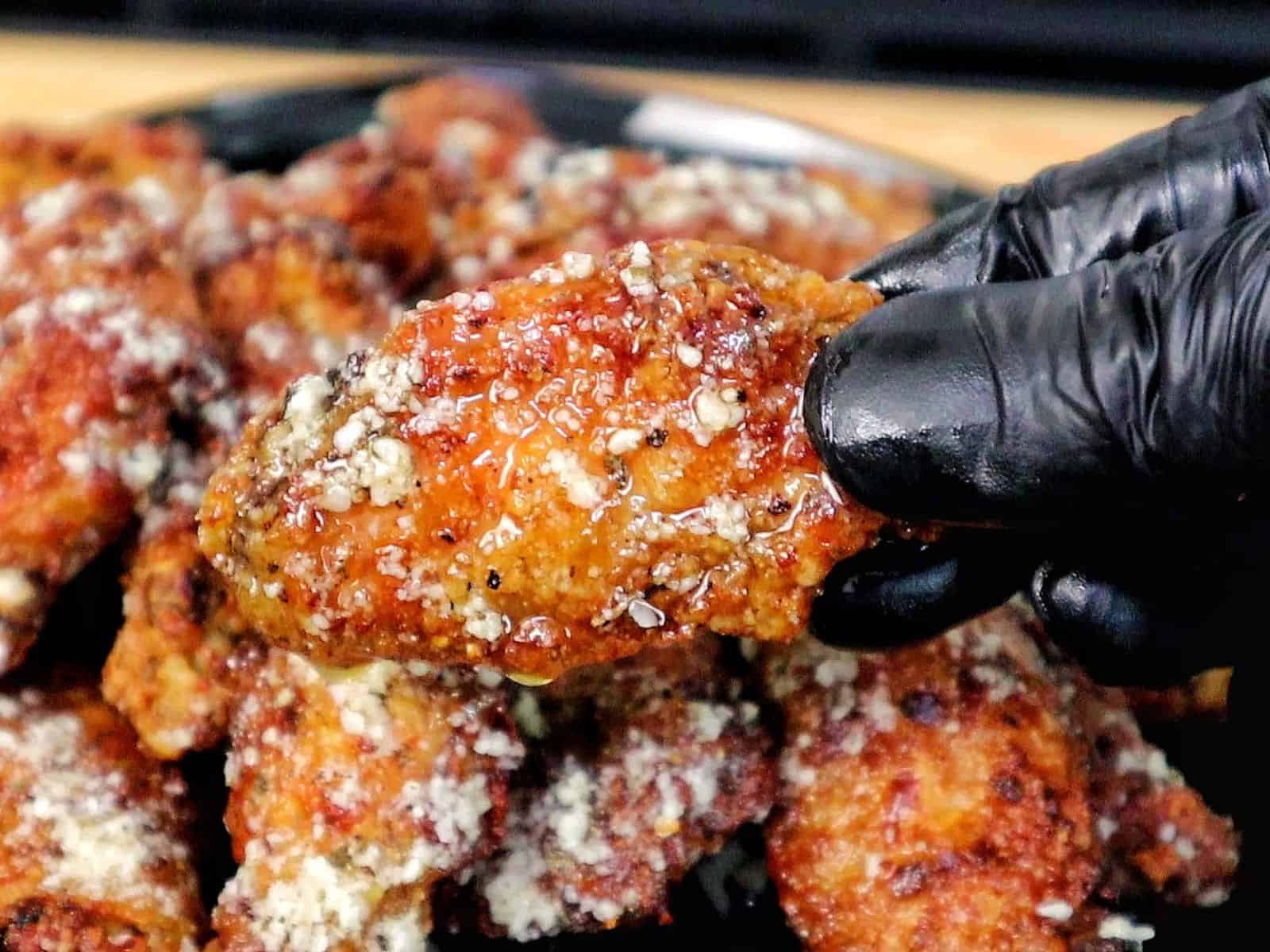 Crispy golden brown garlic Parmesan chicken wings coated in a buttery garlic sauce and topped with grated Parmesan cheese.