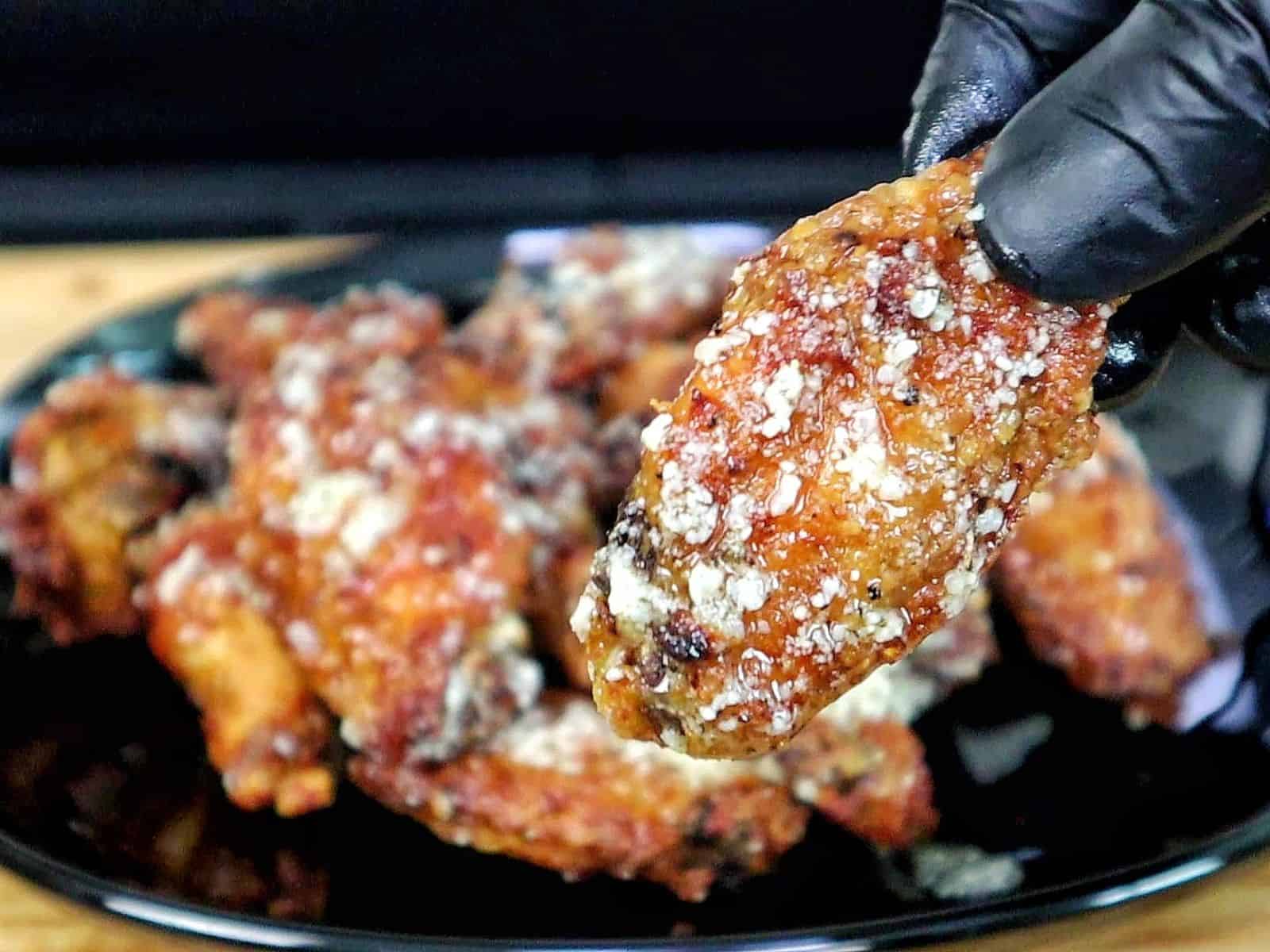 Crispy golden brown garlic Parmesan chicken wings coated in a buttery garlic sauce and topped with grated Parmesan cheese.