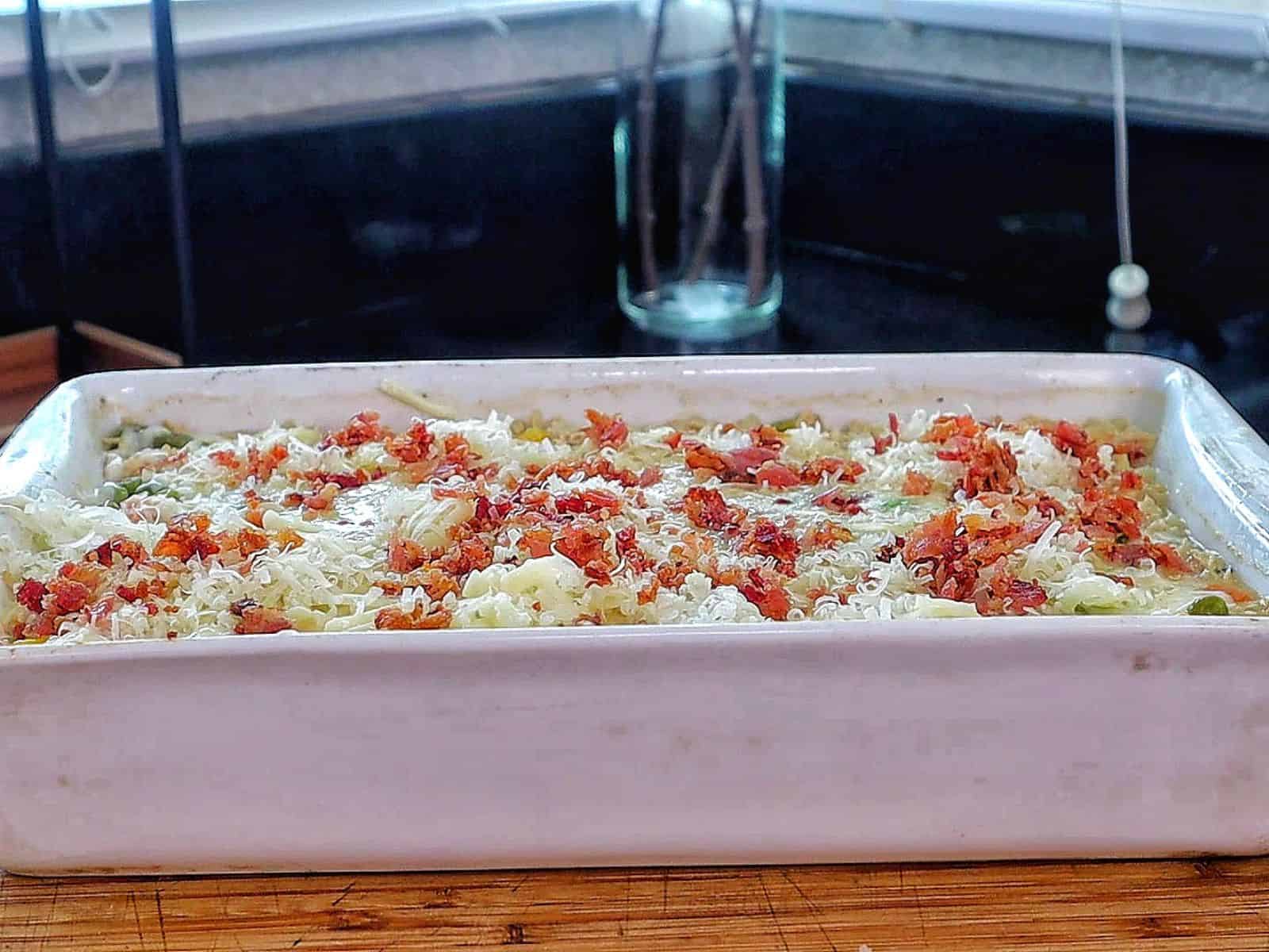 Creamy Chicken Alfredo Rice Casserole baked until golden and bubbly in a casserole dish, loaded with tender shredded chicken, peas, carrots, crispy bacon, melted mozzarella cheese, and a rich Alfredo sauce, garnished with fresh parsley.