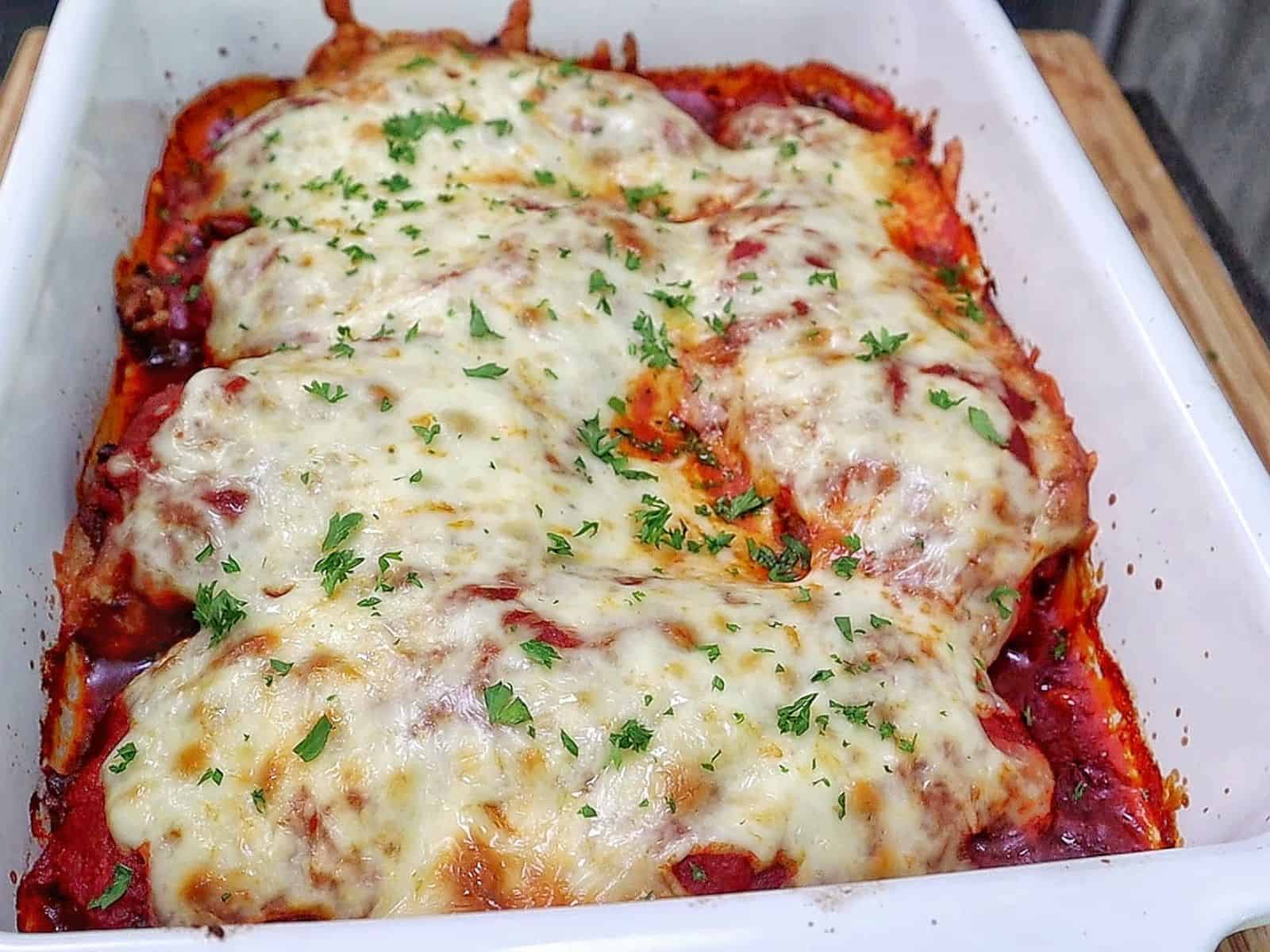 Chicken Parmesan baked in marinara sauce and topped with a thick layer of melted mozzarella cheese garnished with fresh parsley.