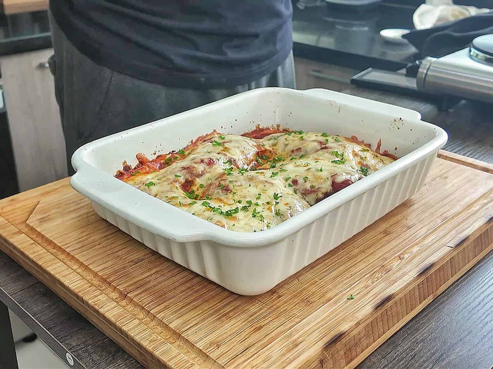 Chicken Parmesan baked in marinara sauce and topped with a thick layer of melted mozzarella cheese garnished with fresh parsley.