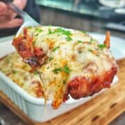 Chicken Parmesan baked in marinara sauce and topped with a thick layer of melted mozzarella cheese garnished with fresh parsley.