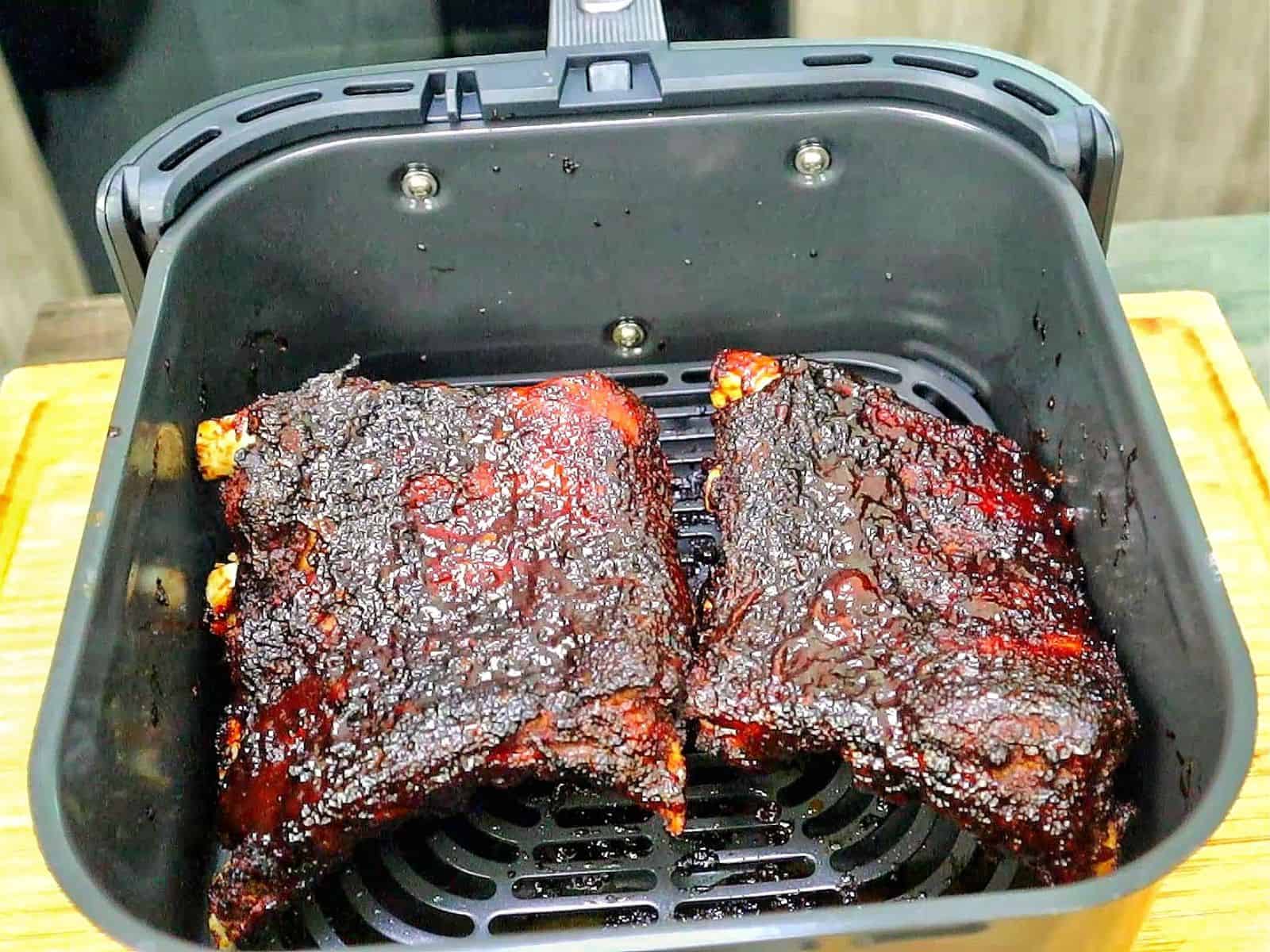 air fryer baby back ribs coated in a dark caramelized BBQ glaze