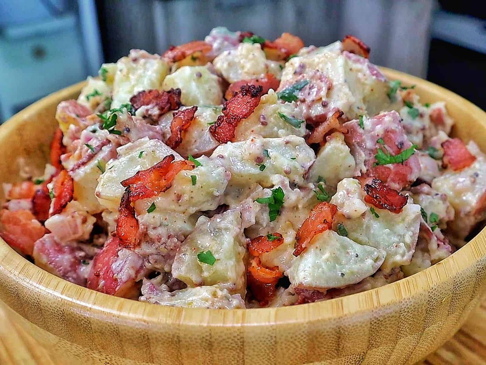 A creamy potato salad made with tender baby potatoes, crispy bacon, red onions, green onions, parsley, and a Dijon mayonnaise dressing.