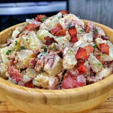 A creamy potato salad made with tender baby potatoes, crispy bacon, red onions, green onions, parsley, and a Dijon mayonnaise dressing.