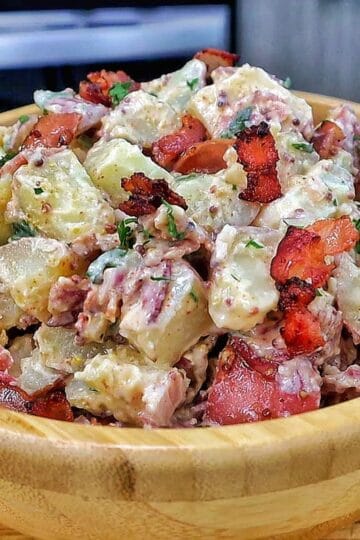 A creamy potato salad made with tender baby potatoes, crispy bacon, red onions, green onions, parsley, and a Dijon mayonnaise dressing.