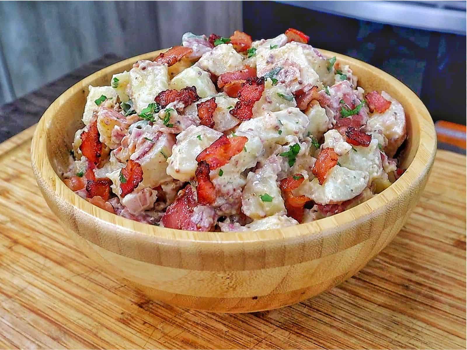 A creamy potato salad made with tender baby potatoes, crispy bacon, red onions, green onions, parsley, and a Dijon mayonnaise dressing.