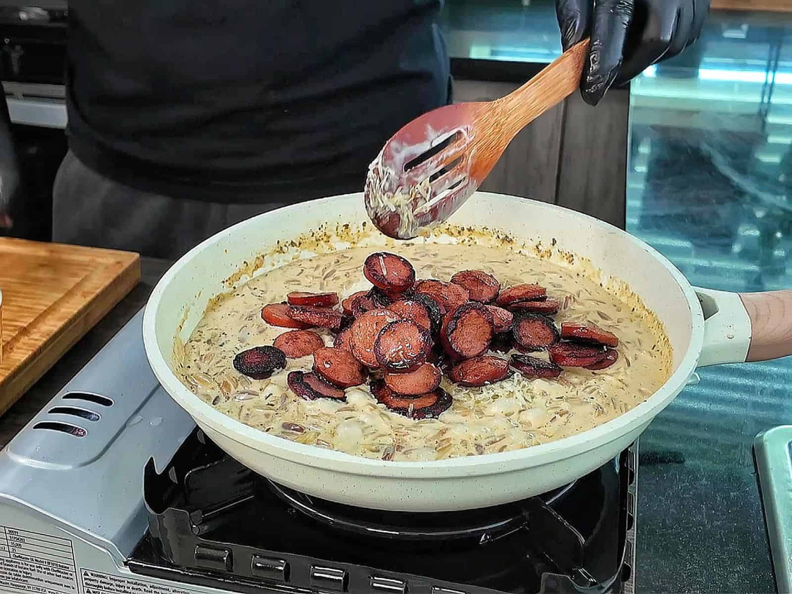 A creamy one-pot garlic butter orzo loaded with browned smoked sausage slices, freshly grated Parmesan cheese, and chopped parsley.