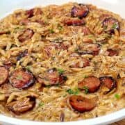A creamy one-pot garlic butter orzo loaded with browned smoked sausage slices, freshly grated Parmesan cheese, and chopped parsley.