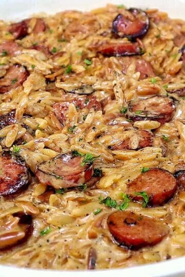 A creamy one-pot garlic butter orzo loaded with browned smoked sausage slices, freshly grated Parmesan cheese, and chopped parsley.