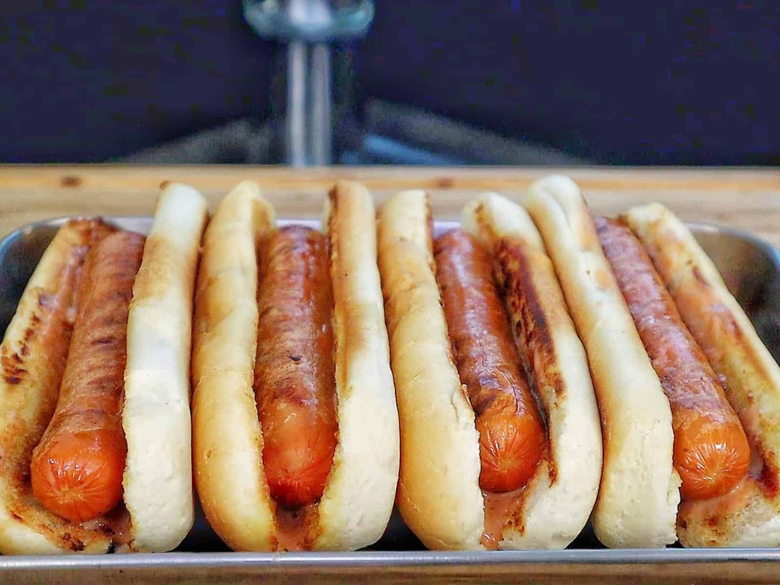 grilled hot dogs in toasted buns topped with melted sharp cheddar cheese, diced red onions, fresh cilantro, jalapeños, and creamy spicy firecracker sauce.