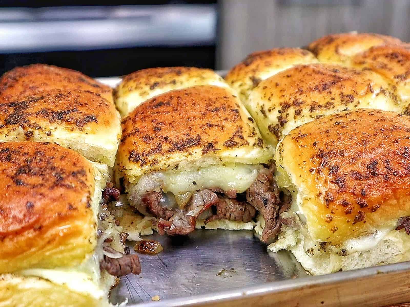 Baked steak and cheese sliders made with tender sirloin steak, caramelized onions, melted provolone cheese, and buttery slider buns.