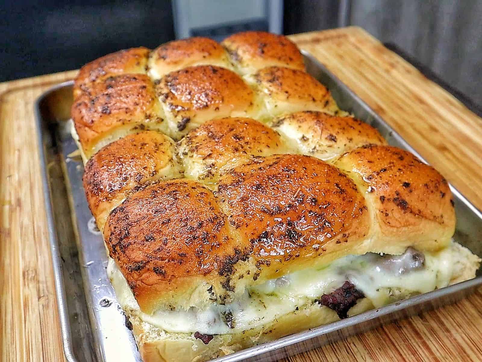 Baked steak and cheese sliders made with tender sirloin steak, caramelized onions, melted provolone cheese, and buttery slider buns.