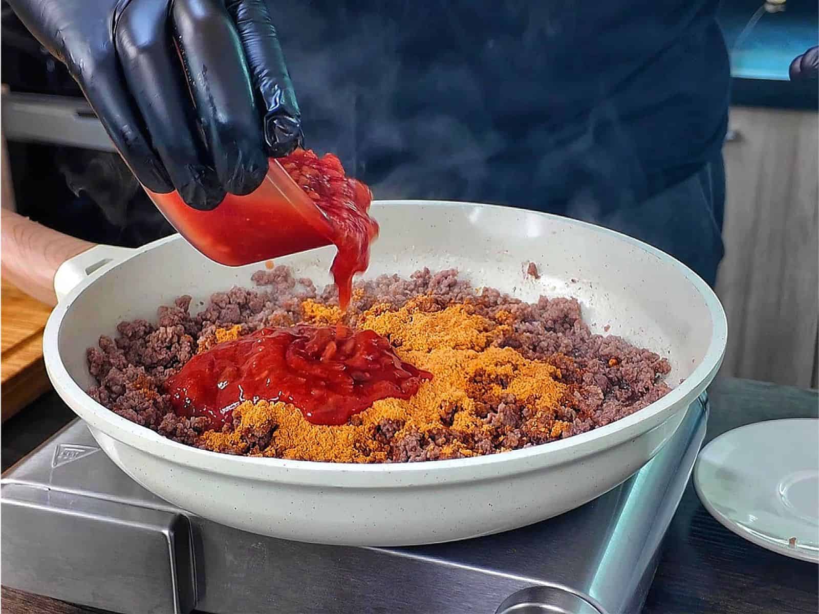 A cheesy Taco Potato Bake made with layers of seasoned ground beef, tender sliced potatoes, salsa, melted Mexican cheese, and topped with fresh green onions and sour cream.