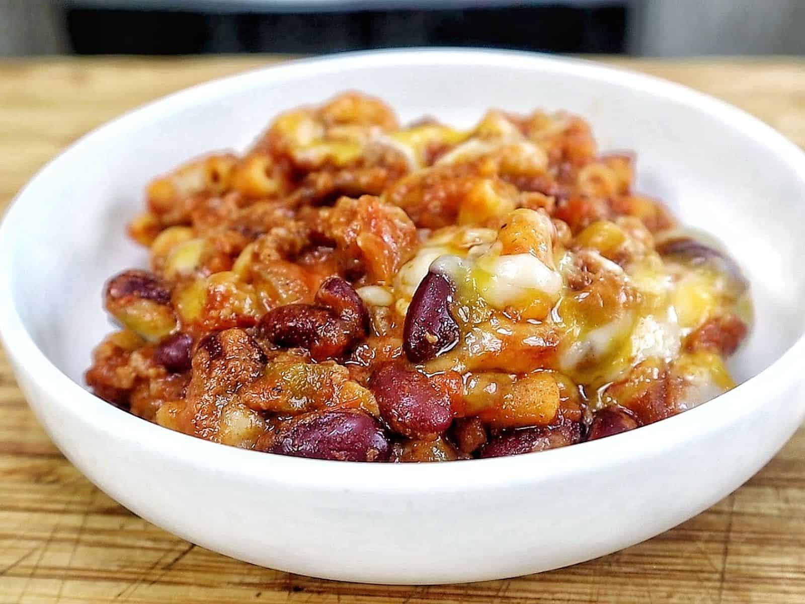 cheesy homemade chili mac made with elbow macaroni, seasoned ground beef, kidney beans, rich tomato sauce, and melted cheddar, Monterey Jack, and mozzarella cheese.