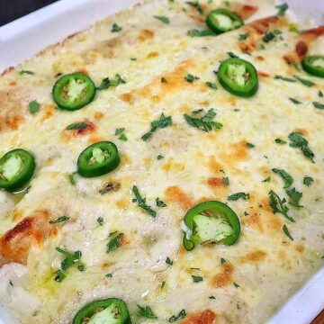 Creamy shrimp enchiladas baked, topped with melted Monterey Jack cheese, sliced jalapeños, and fresh cilantro covered in a rich salsa verde cream sauce.