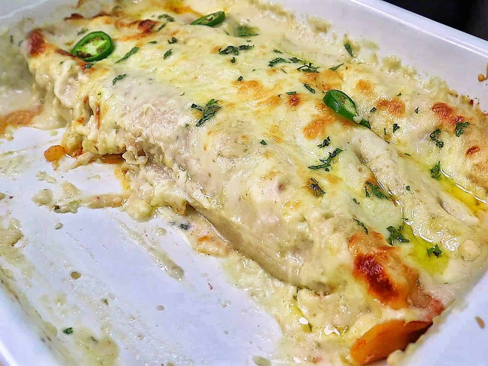 Creamy shrimp enchiladas baked, topped with melted Monterey Jack cheese, sliced jalapeños, and fresh cilantro covered in a rich salsa verde cream sauce.