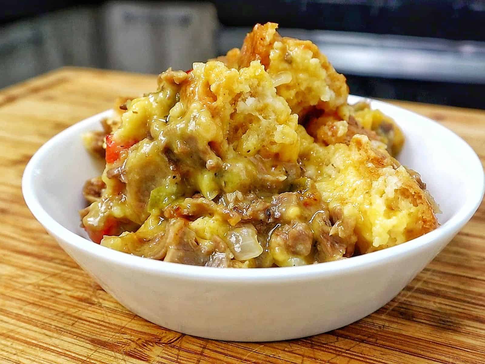 Philly Cheesesteak Cheddar Bay Cobbler topped with golden Cheddar Bay biscuit crust, filled with chopped roast beef, onions, bell peppers, and creamy cheddar cheese sauce.