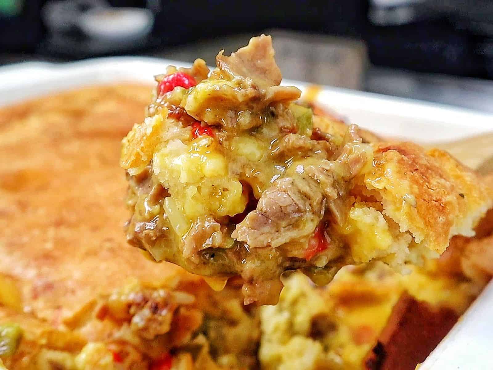 Philly Cheesesteak Cheddar Bay Cobbler topped with golden Cheddar Bay biscuit crust, filled with chopped roast beef, onions, bell peppers, and creamy cheddar cheese sauce.