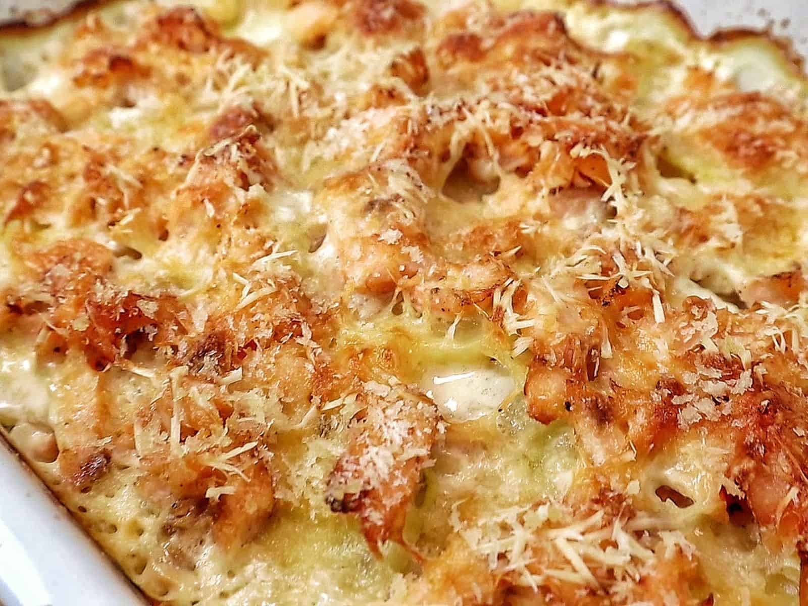 Golden brown salmon potato au gratin baked in a casserole dish with layers of tender sliced potatoes, flaky salmon, creamy parmesan sauce, and a crispy panko topping.