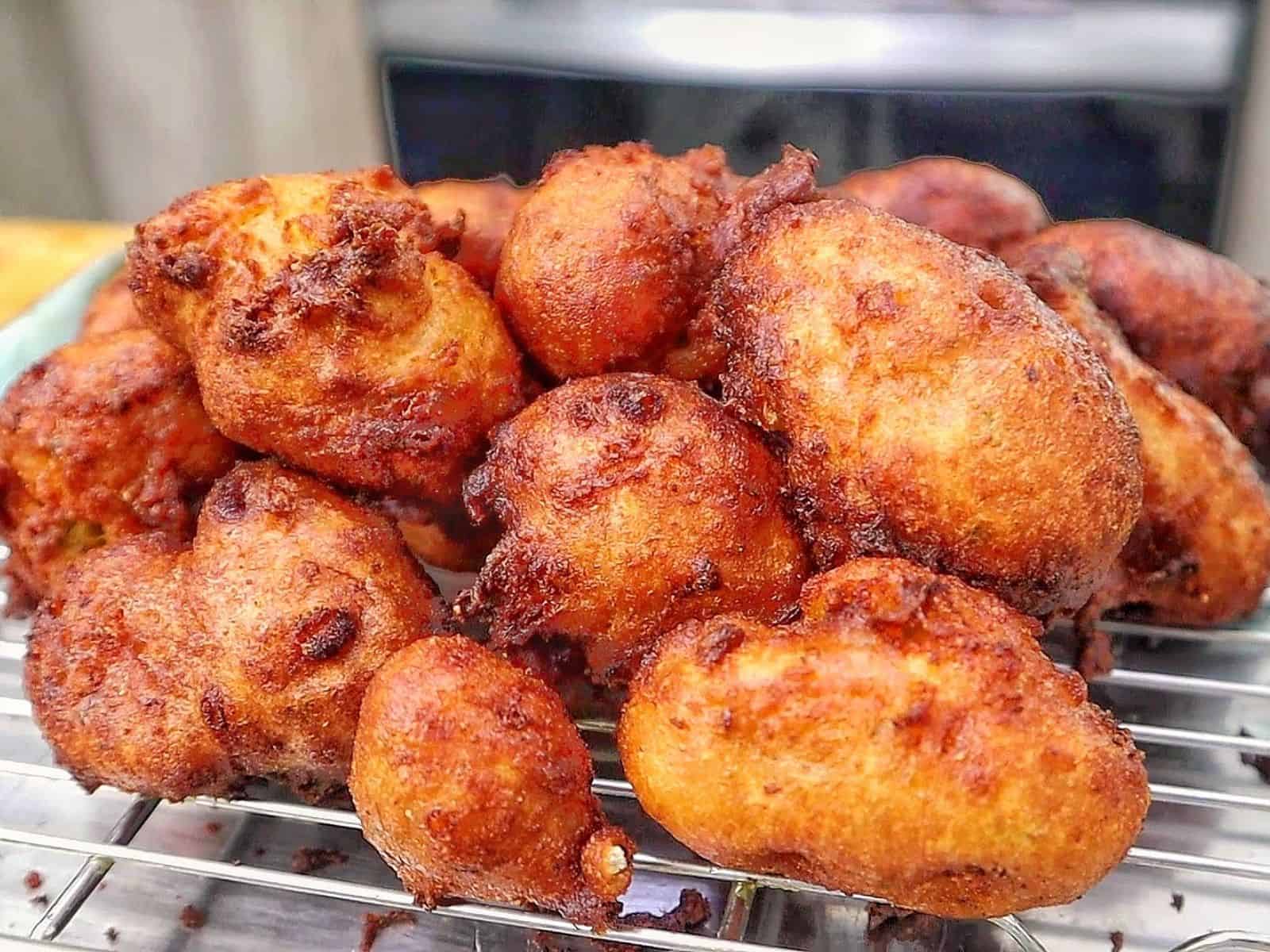 Golden-brown Cajun hush puppies made with seasoned hushpuppy batter, cheddar cheese, onion, and jalapeño, fried until crispy outside and soft and fluffy inside.