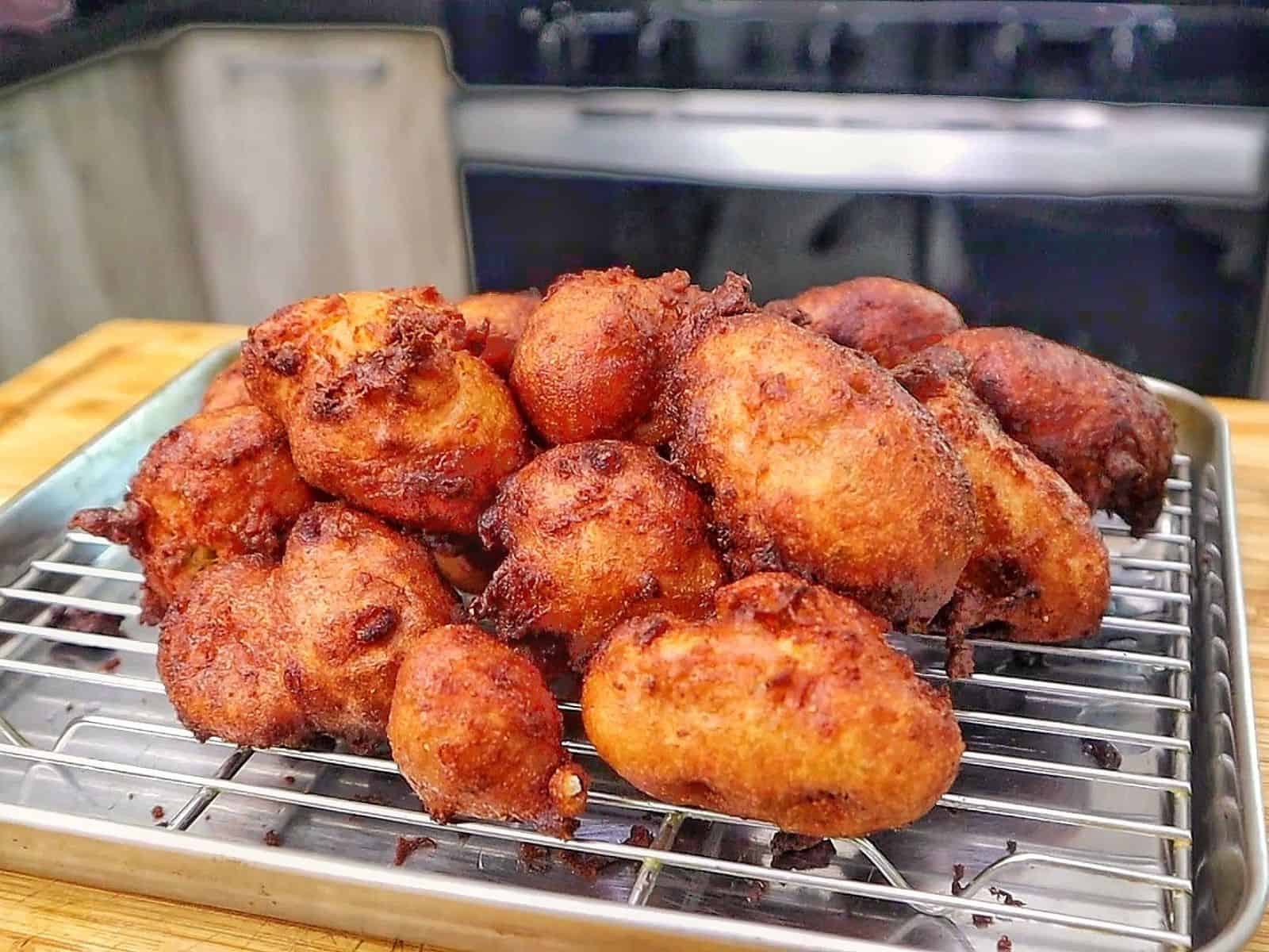 Golden-brown Cajun hush puppies made with seasoned hushpuppy batter, cheddar cheese, onion, and jalapeño, fried until crispy outside and soft and fluffy inside.