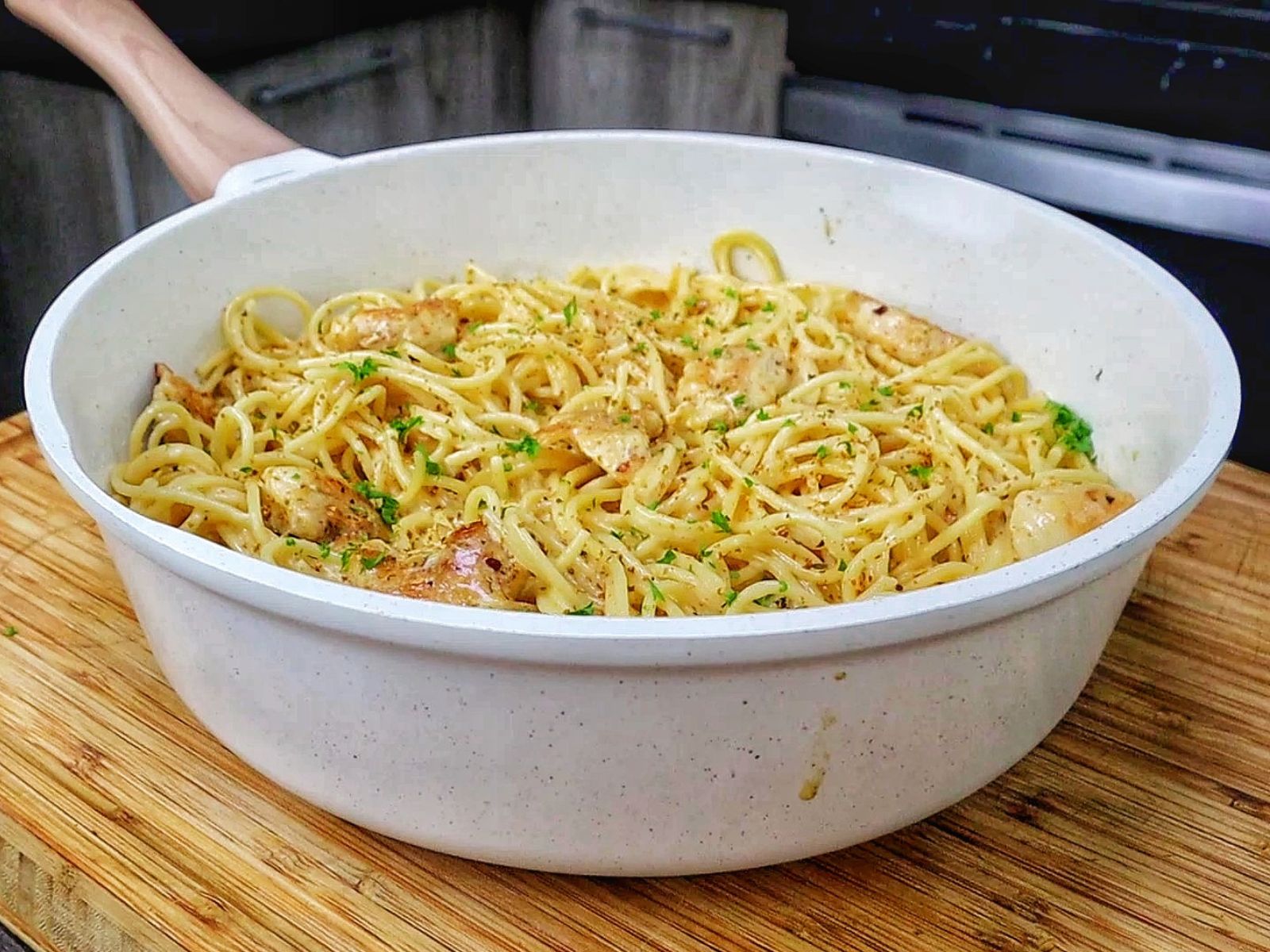Three Cheese Chicken Spaghetti made with tender golden chicken breast, spaghetti coated in a rich Cajun garlic Parmesan cream sauce, and topped with fresh parsley.