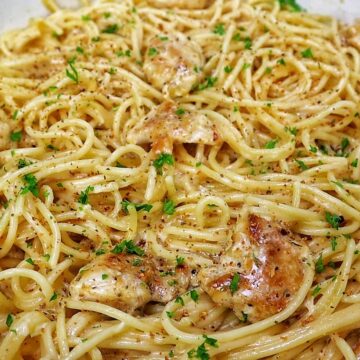 Three Cheese Chicken Spaghetti made with tender golden chicken breast, spaghetti coated in a rich Cajun garlic Parmesan cream sauce, and topped with fresh parsley.