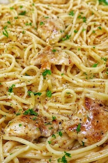 Three Cheese Chicken Spaghetti made with tender golden chicken breast, spaghetti coated in a rich Cajun garlic Parmesan cream sauce, and topped with fresh parsley.