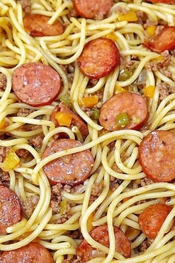Close-up of Dirty Spaghetti made with tender spaghetti noodles, seasoned ground beef, sliced smoked sausage, onions and colorful bell peppers tossed in a rich, savory beef sauce.