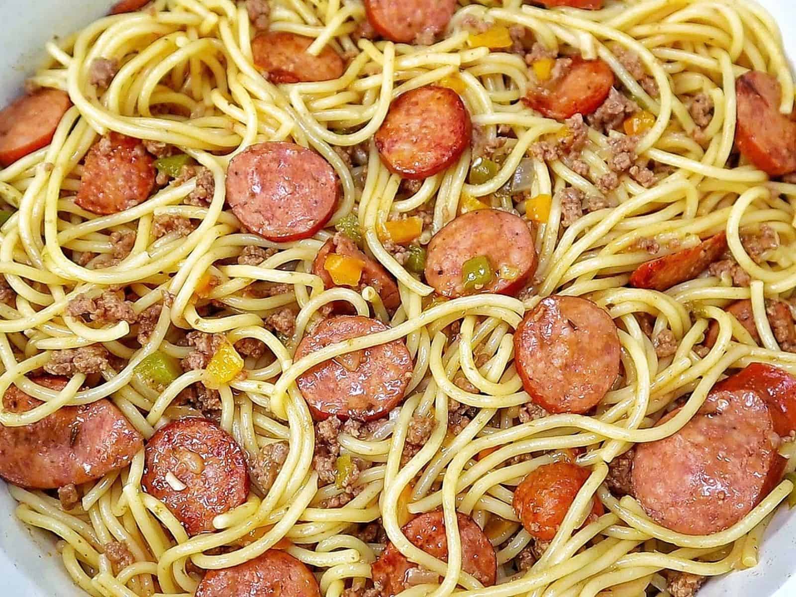 Close-up of Dirty Spaghetti made with tender spaghetti noodles, seasoned ground beef, sliced smoked sausage, onions and colorful bell peppers tossed in a rich, savory beef sauce.
