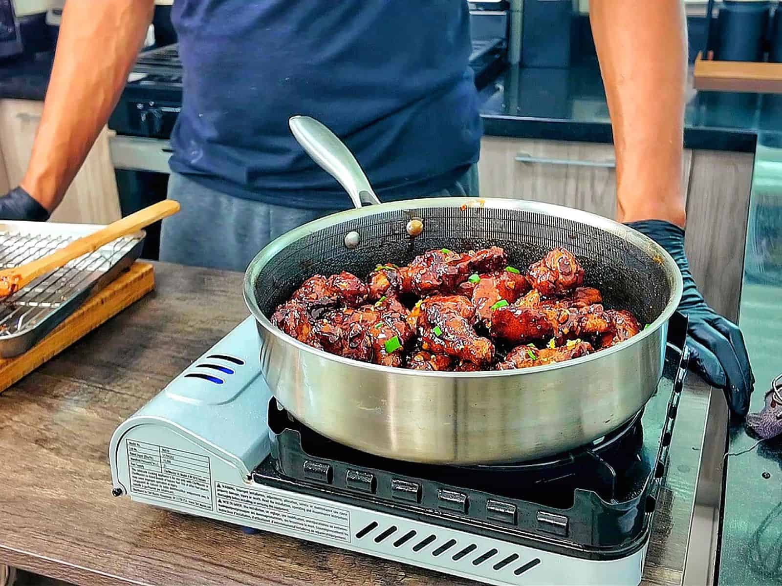 Crispy garlic soy chicken wings coated in a glossy sweet and savory soy garlic glaze, garnished with fresh green onions and lemon zest.