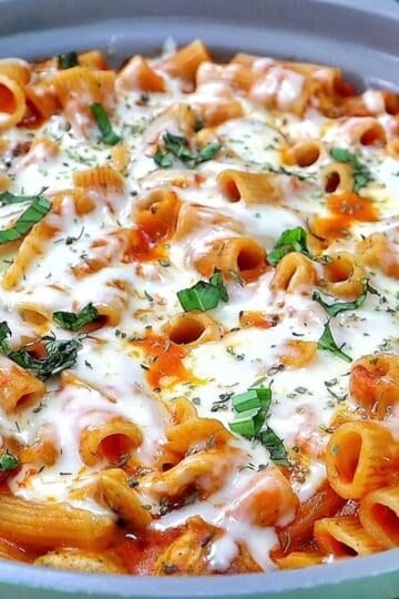 Cheesy Chicken Parmesan Pasta made with rigatoni, seasoned chicken, marinara sauce, melted mozzarella and Parmesan cheese, finished with fresh basil and Italian herbs.