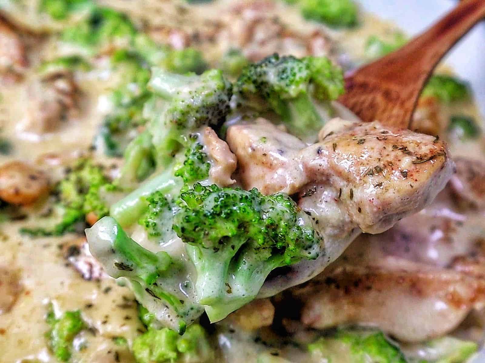 Tender seasoned chicken and fresh broccoli florets coated in a rich, creamy three-cheese garlic sauce in a skillet