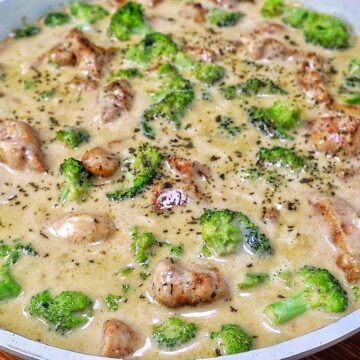 Tender seasoned chicken and fresh broccoli florets coated in a rich, creamy three-cheese garlic sauce in a skillet