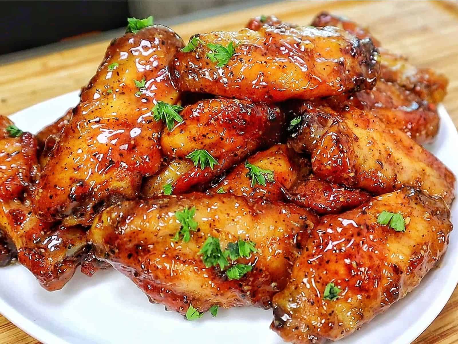 Crispy baked lemon pepper chicken wings coated in a sticky honey lemon glaze and garnished with fresh chopped parsley.