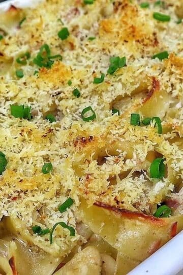 Homemade tuna noodle casserole made with wide egg noodles, tuna, peas and a creamy white cheddar sauce, topped with crispy golden Parmesan Panko breadcrumbs and fresh chopped chives.
