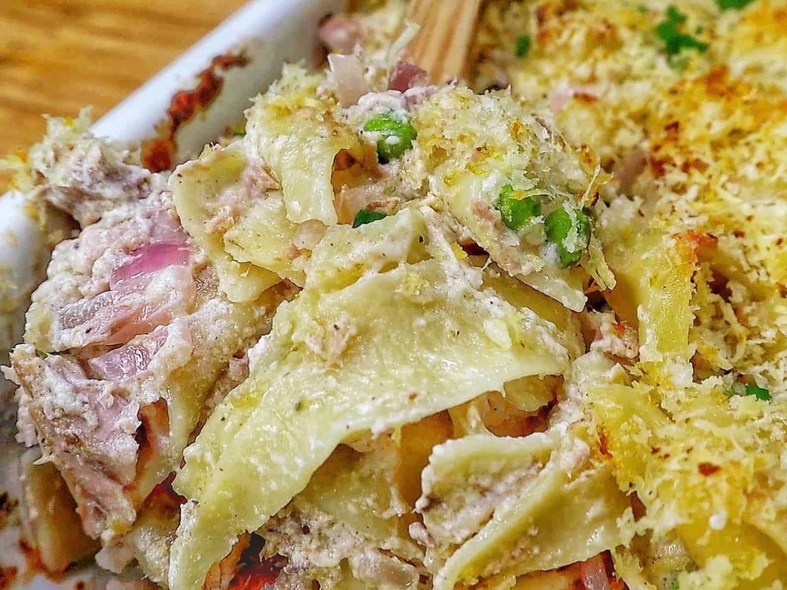 Homemade tuna noodle casserole made with wide egg noodles, tuna, peas and a creamy white cheddar sauce, topped with crispy golden Parmesan Panko breadcrumbs and fresh chopped chives.