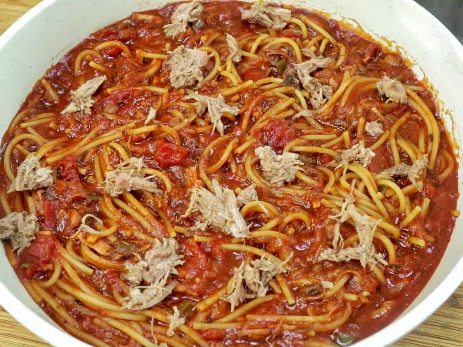 Close-up of BBQ Pulled Pork Spaghetti featuring shredded pork, spaghetti noodles, diced tomatoes, and a thick, smoky barbecue tomato sauce.