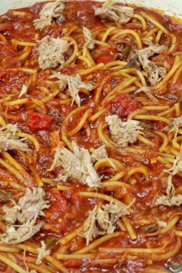 Close-up of BBQ Pulled Pork Spaghetti featuring shredded pork, spaghetti noodles, diced tomatoes, and a thick, smoky barbecue tomato sauce.